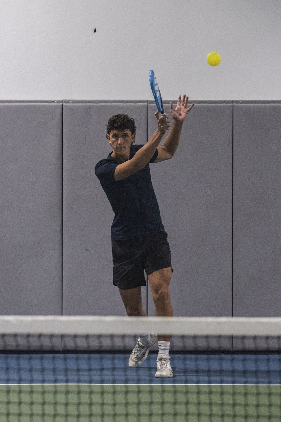 Player hitting an overhead shot at the net