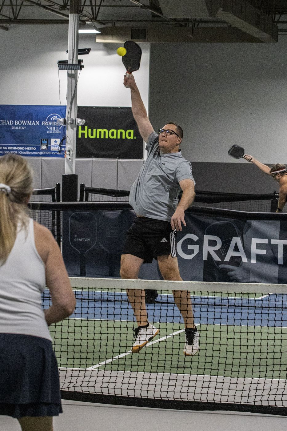 Player reaching high for an overhead
