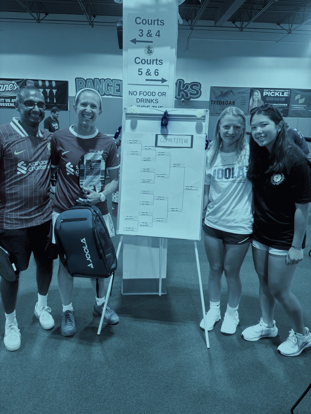 Players gathered beside the tournament bracket board