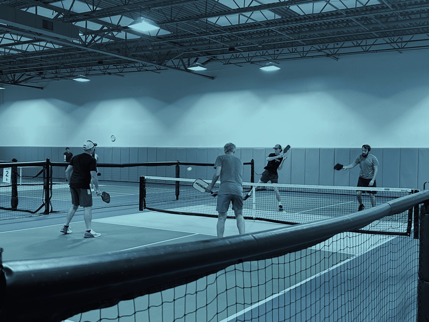 Doubles rally in progress on the indoor courts