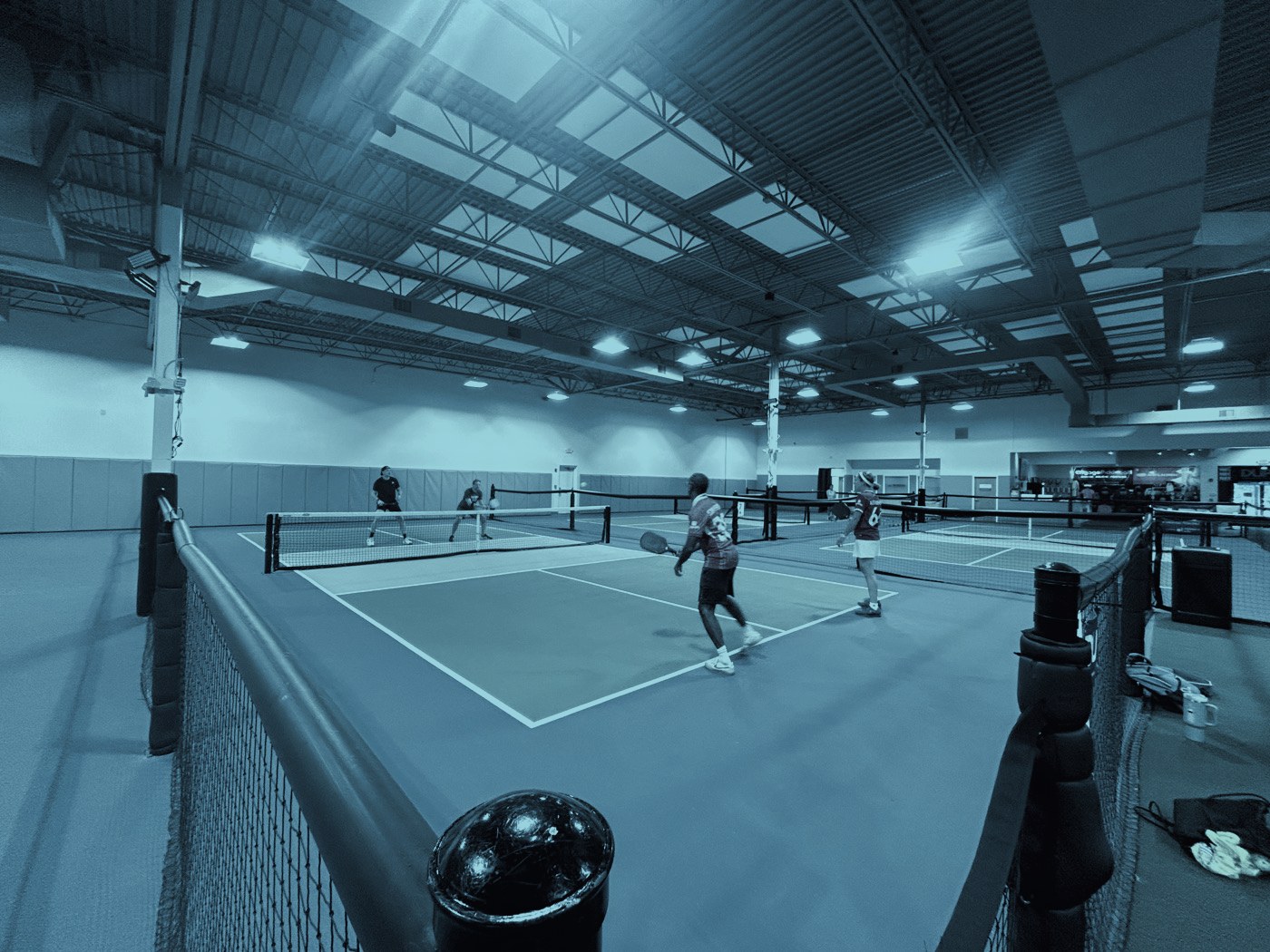 Players rallying across adjacent courts