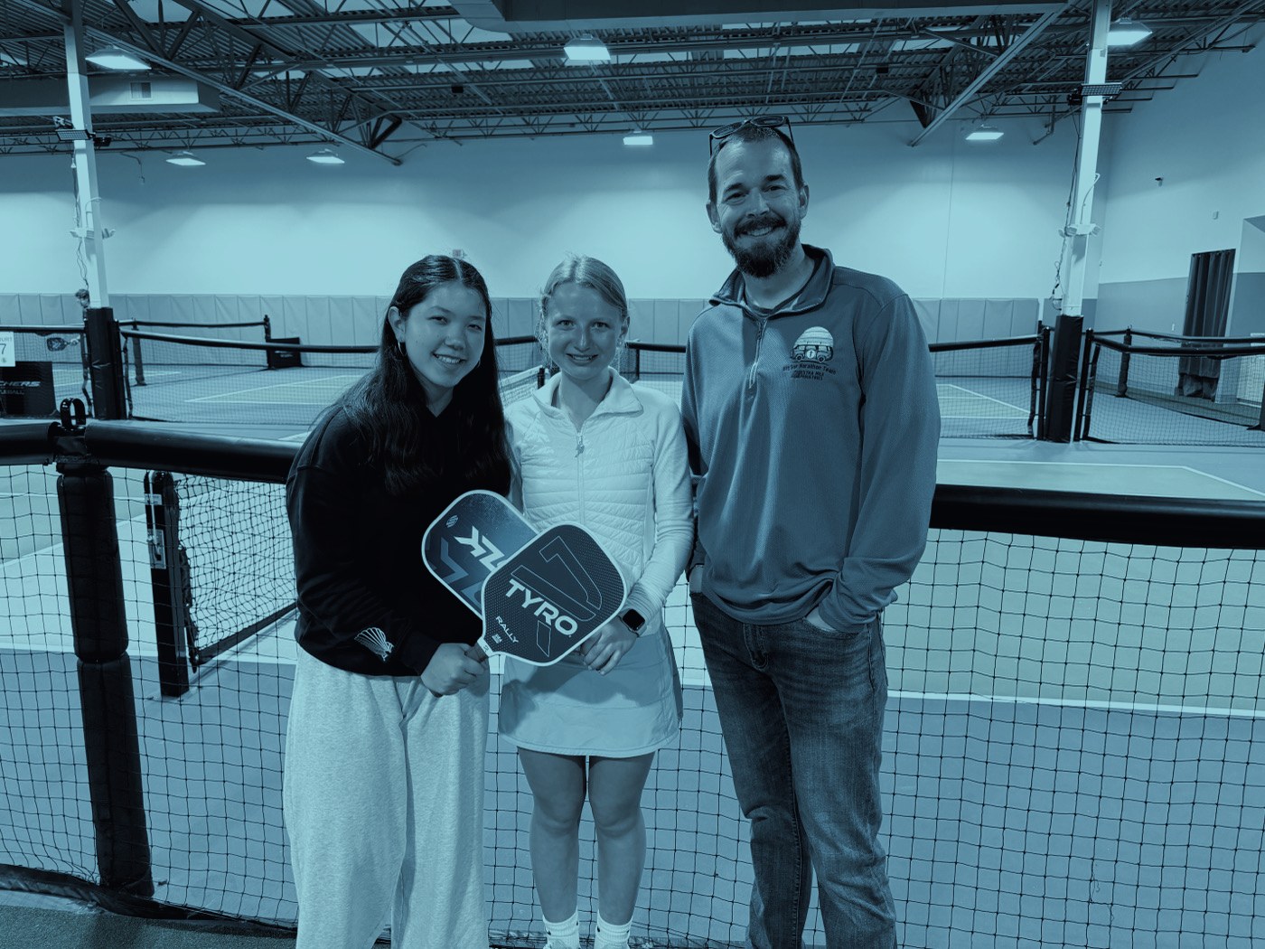 Players and a partner representative with a paddle